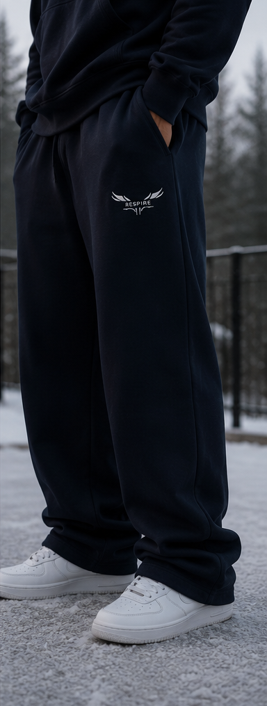 Man wearing Respire Alpine Sweats in navy blue, showcasing comfort and style in a snowy outdoor setting.